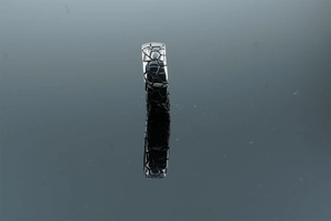 Detailed macro shot of vintage silver ring with geometric cracked texture and reflection