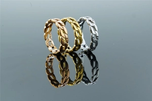 Detailed view of woven chain rings in rose gold, gold, and silver stainless steel
