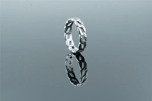 Macro shot of silver stainless steel Cuban link ring with hollow chain design and reflection
