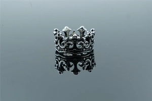 Macro shot of vintage gothic crown ring with fleur-de-lis and skull details in steel