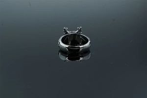 Macro detail of retro dragon head ring with intricate antlers on dark reflective base