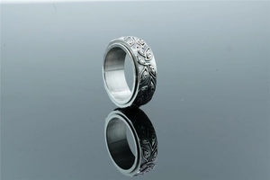 Macro shot of vintage spinner ring with engraved eye pattern and silver leaf texture