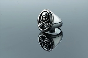 Macro detail of men's punk skull and guitar ring with vintage polished silver finish