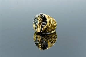 Gros plan détaillé de la bague pharaon Toutânkhamon dorée avec accents en émail noir et relief