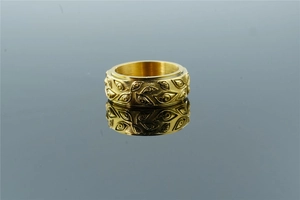 Detailed macro of gold spinner ring featuring embossed eye pattern and rotating band