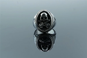 Detail view of punk rocker skull and crossed guitars engraving on a stainless steel ring