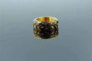 Macro detail of vintage gold steel ring featuring embossed eye pattern with antique finish