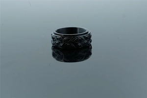 Macro shot of matte black stainless steel ring featuring embossed evil eye patterns