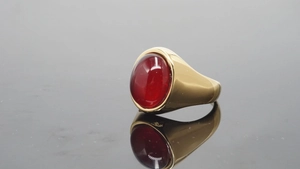 Macro-opname van een vintage gouden ring met grote rode edelsteen op reflecterend vlak