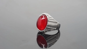 Makroaufnahme eines silbernen Rings im Industriestil mit großem rotem ovalem Edelstein