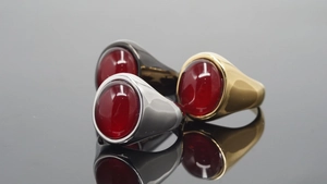 Macro-opname van edelstalen edelsteenringen in goud, zilver en zwart op een glanzend oppervlak