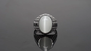 Makroaufnahme eines Herrenrings im Industrial-Stil mit ovalem weißem Katzenaugenstein