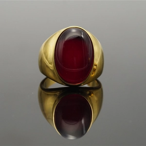 Anello ovale in titanio dorato con pietra cabochon rosso intenso su base a specchio