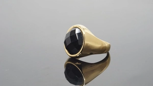Detalle de un anillo de banda ancha dorado vintage con una gran piedra preciosa negra ovalada