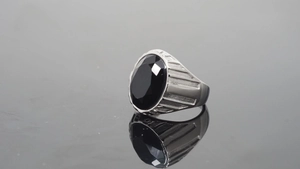 Makro-Detail eines Herren-Titanrings mit ovalem schwarzem Edelstein und Silberband