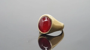 Macro-opname van een gouden ring met een grote ronde rode cabochon geslepen edelsteen