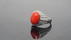 Detailansicht eines Edelstahlrings für Herren mit einem großen roten Cabochon-Stein