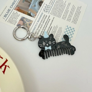 Porte-clés peigne en acétate forme chat noir avec petit chapeau de fête bleu