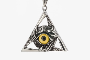 Macro detail of gothic triangular pendant with realistic yellow eye and carved hands