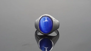 Detailopname van een ovale blauwe kattenoogsteen gezet in een gepolijste zilveren ring