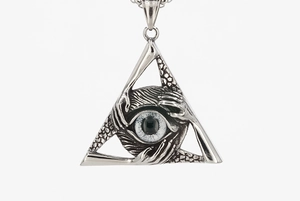 Detailed macro view of a silver titanium steel occult eye pendant with hand motifs