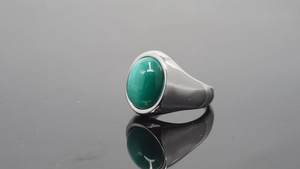 Vista macro de un anillo de sello de acero plateado con piedra ovalada verde