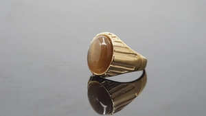 Detail eines Herrenrings aus Gold mit braunem Tigerauge und seitlicher Rippenstruktur