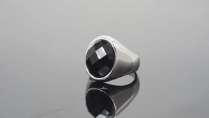 Detalle de anillo de acero pulido con una gran piedra preciosa negra redonda facetada