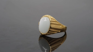 Nahaufnahme des Herren-Goldrings mit weißem Edelstein und gestuften Rillen am Metallband