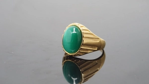 Detailansicht des goldenen Herrenrings mit grünem Edelstein und tiefen Seitenrillen