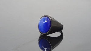 Vista macro de un anillo retro de acero inoxidable negro con piedra ovalada azul ojo de gato
