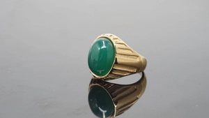Makroaufnahme eines Vintage-Goldrings für Herren mit ovalem grünem Edelsteinband