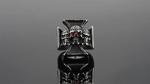 Macro view of gothic skull ring with red zircon eyes and iron cross details in silver
