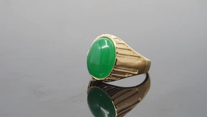 Detail eines Herrenrings mit grünem Steinbesatz und industrieller Stufenstruktur an der Seite
