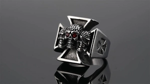 Detail of punk titanium steel ring with triple skulls and red zircon eyes