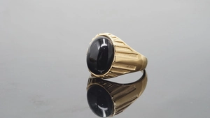 Makroansicht goldener Vintage-Ring mit ovalem schwarzen Stein und Rippentextur
