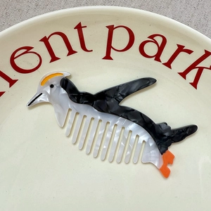 Cute penguin-shaped acetate hair comb with black and white marble texture