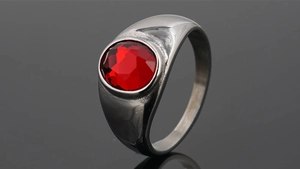 Primer plano de un anillo de acero inoxidable plateado con una gran gema roja ovalada