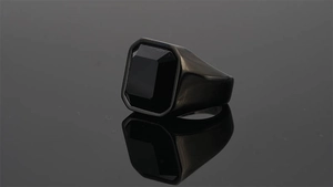 Macro detail of men's black titanium ring featuring a large rectangular cut gemstone