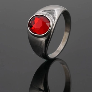 Anillo de acero inoxidable pulido con una vibrante gema roja ovalada en fondo negro