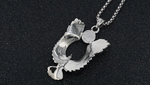 Dettaglio ravvicinato del ciondolo aquila argento con turchese blu e ali piumate