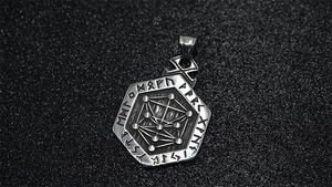 Macro detail of Nordic Runes and geometric symbols on a vintage silver hexagonal pendant