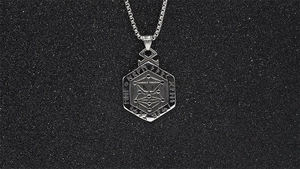 Macro detail of Nordic rune engravings on a vintage silver hexagonal pendant necklace