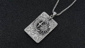 Détail macro du pendentif vintage en acier argenté avec motifs de lune et soleil