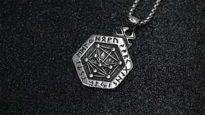 Macro shot of Viking hexagon pendant with engraved runes and vintage oxidized metal finish