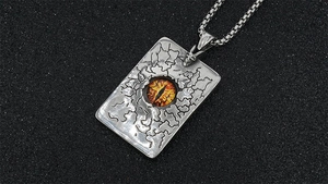 Détail macro du pendentif gothique en acier inoxydable avec œil de dragon et texture craquelée