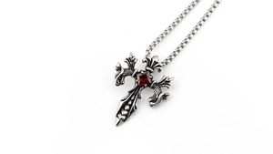 Detailed view of Gothic cross pendant with red gemstone on a silver chain