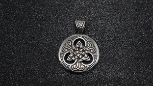 Primer plano de colgante nudo celta Triquetra de acero con grabados ornamentados