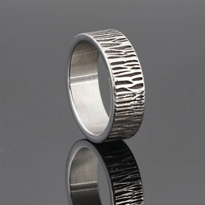Adjustable minimalist silver ring with textured bark pattern on reflective surface