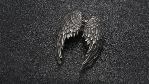 Detailed close-up of gothic silver angel wings pendant with intricate feather textures